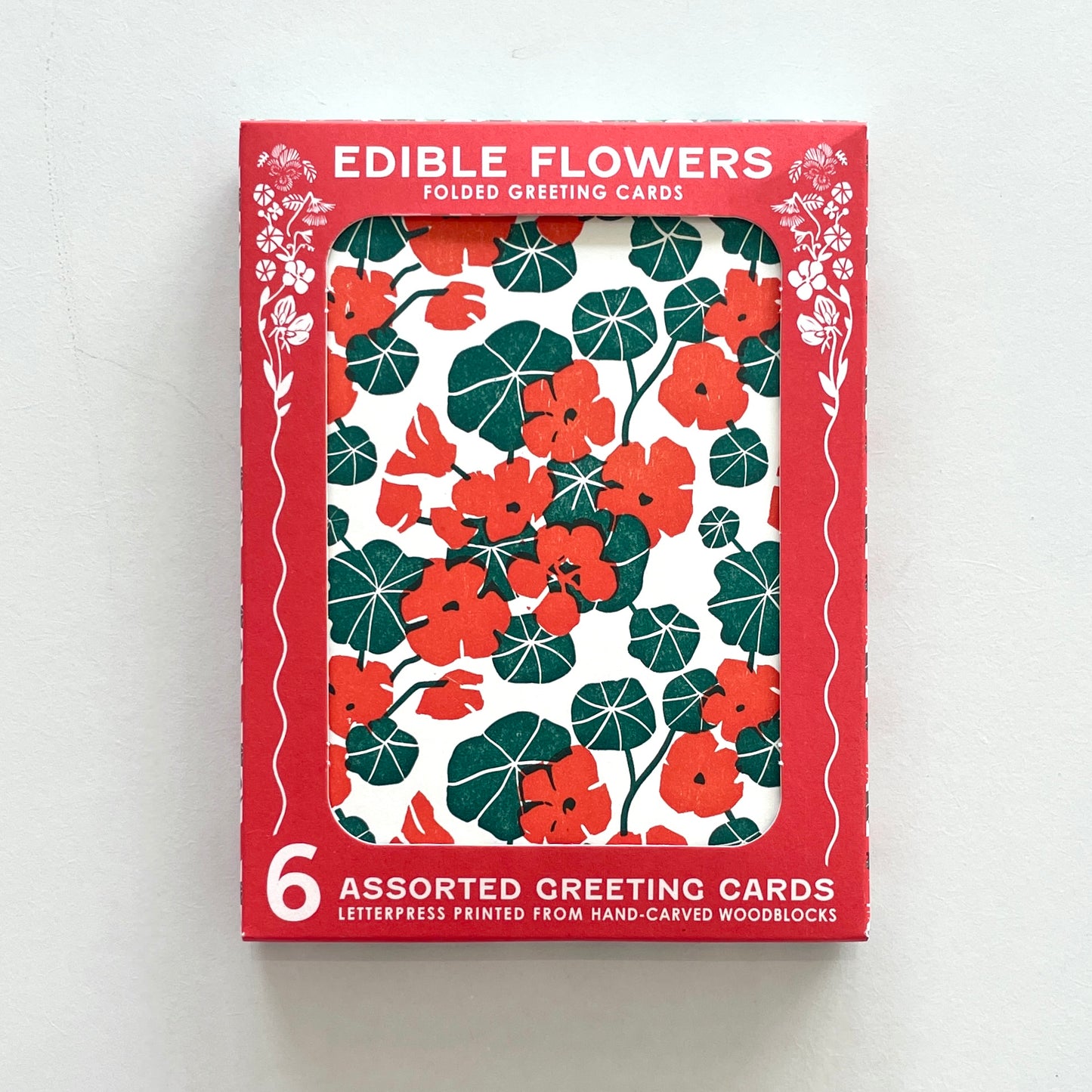 A boxed set of floral greeting cards in red packaging on a white background.