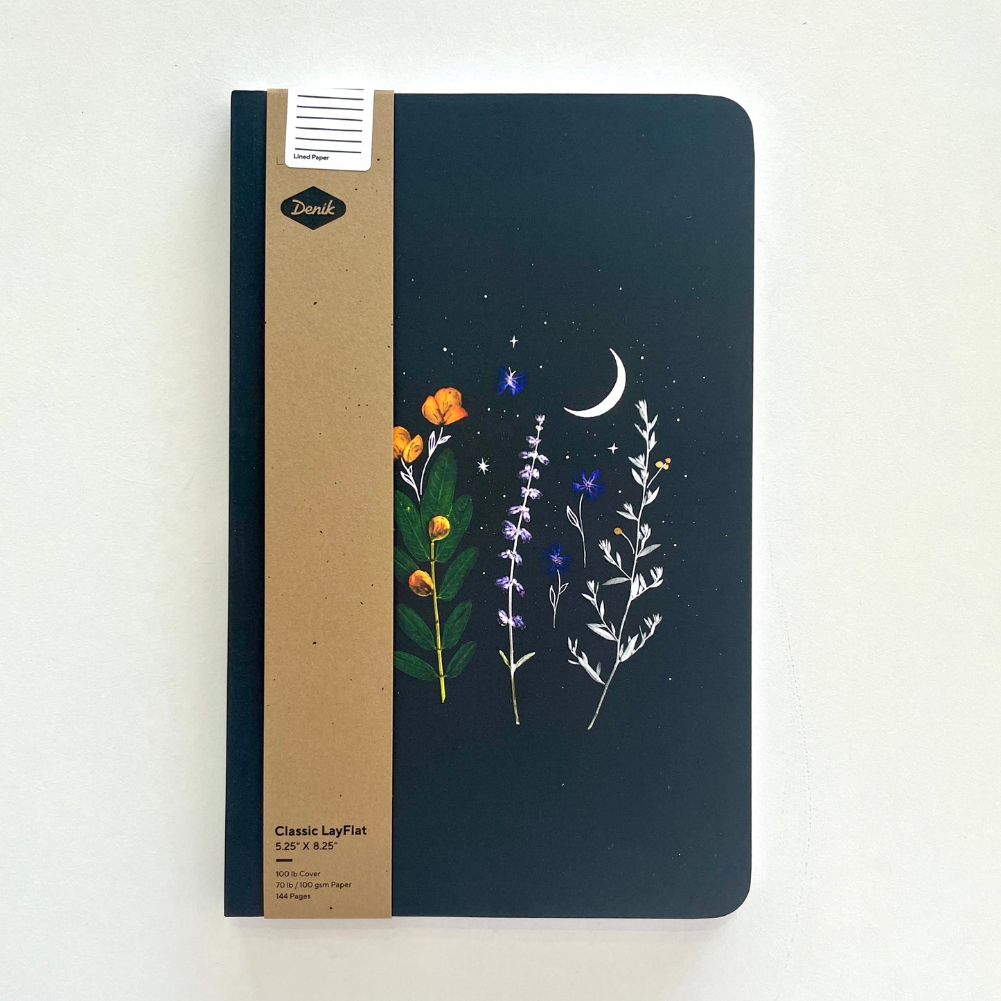 A black softcover notebook with floral design on a gray background