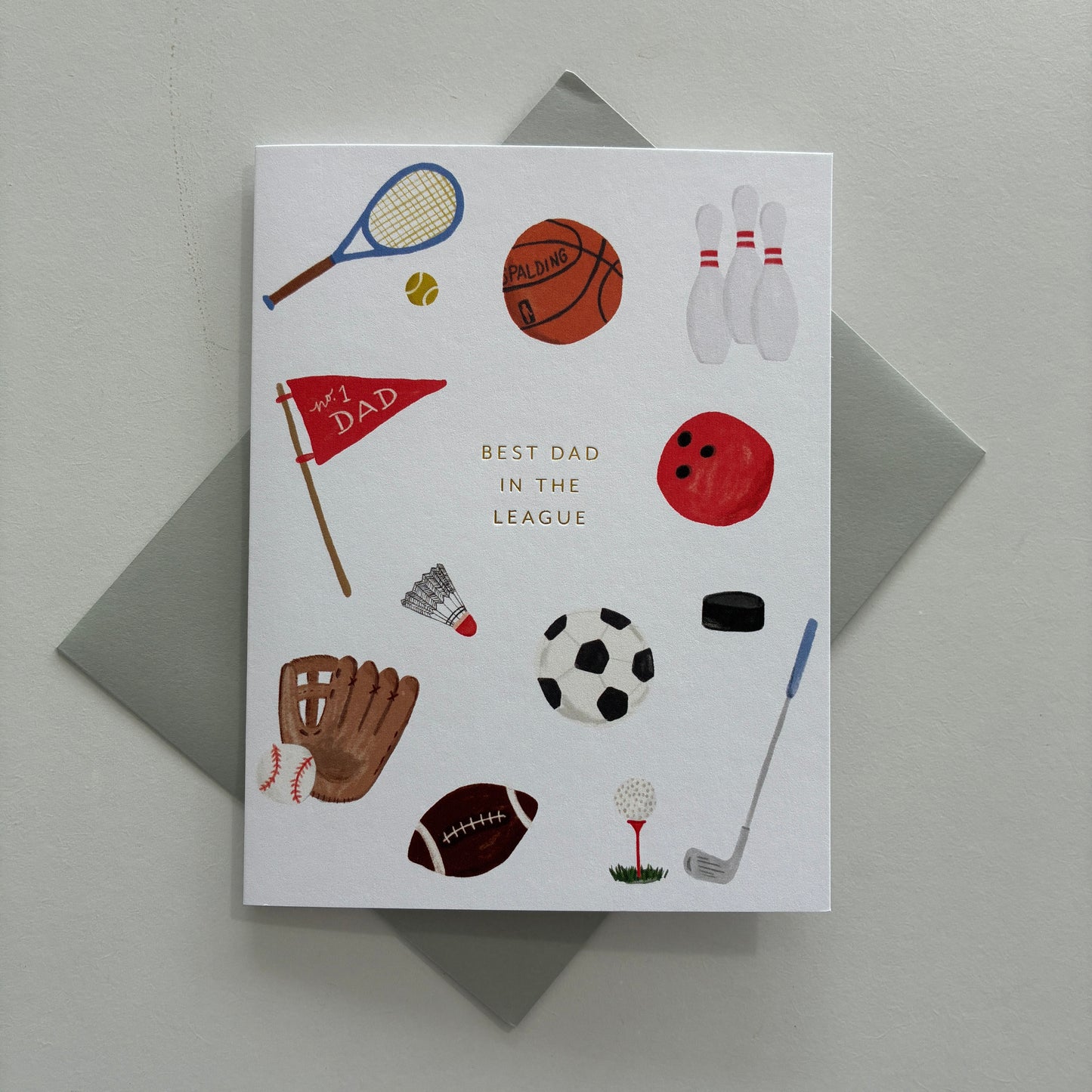 Greeting card with sports-themed illustrations and text saying "Best Dad in the league" on a gray background