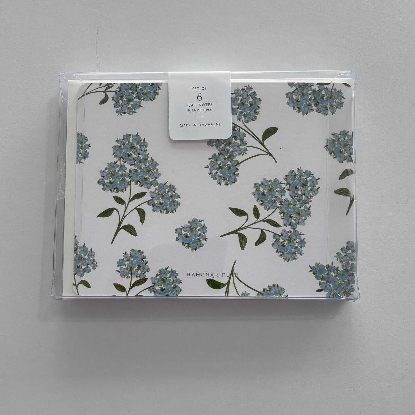 Packaged set of floral notecards with a clear cover on a gray background