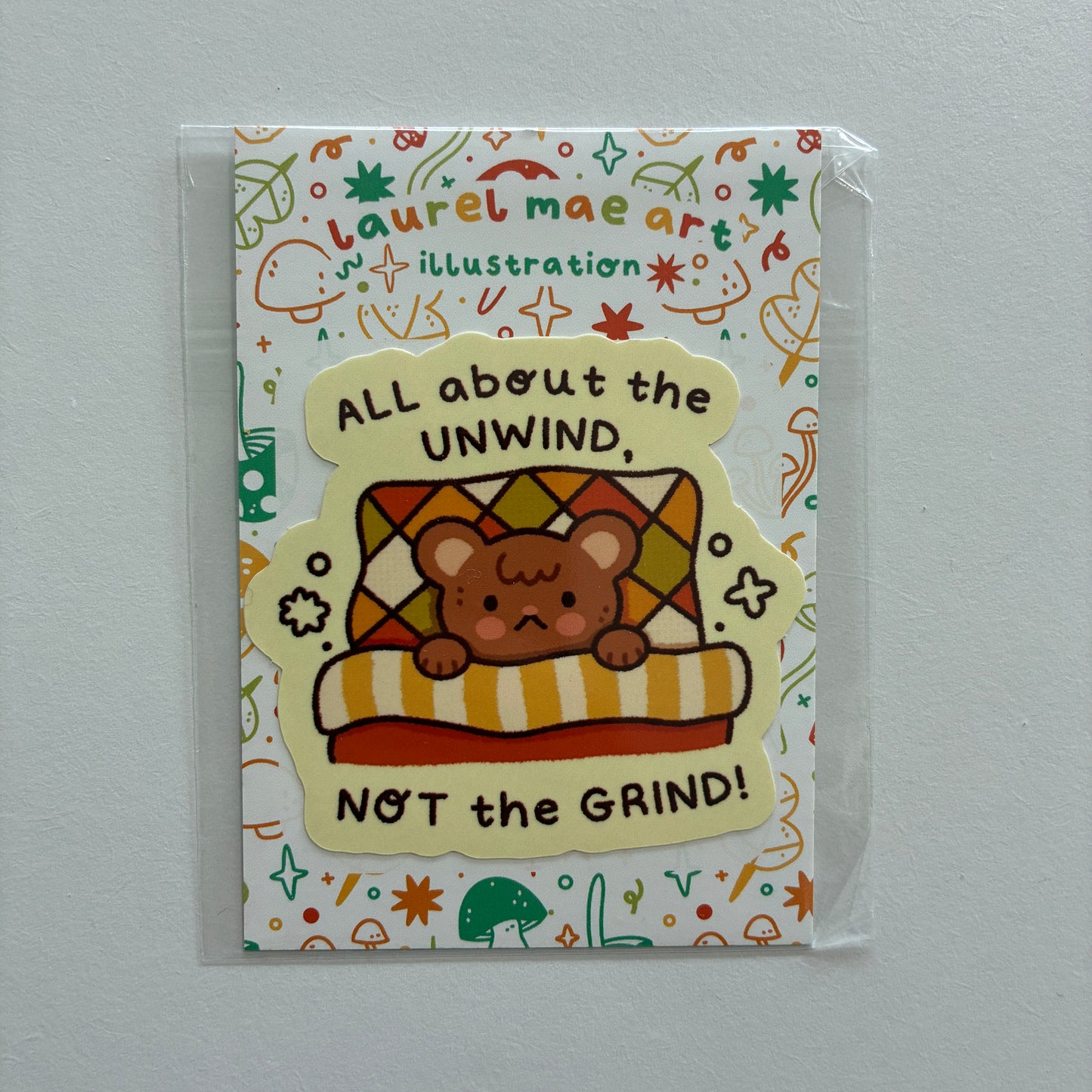 Bear in bed illustration with text saying “all about the unwind, not the grind!”