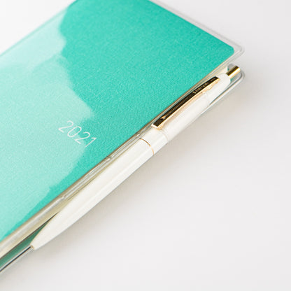 A close-up of a 2021 pocket calendar with a textured mint green cover and a white pen resting inside a clear plastic sleeve, set against a clean white background.