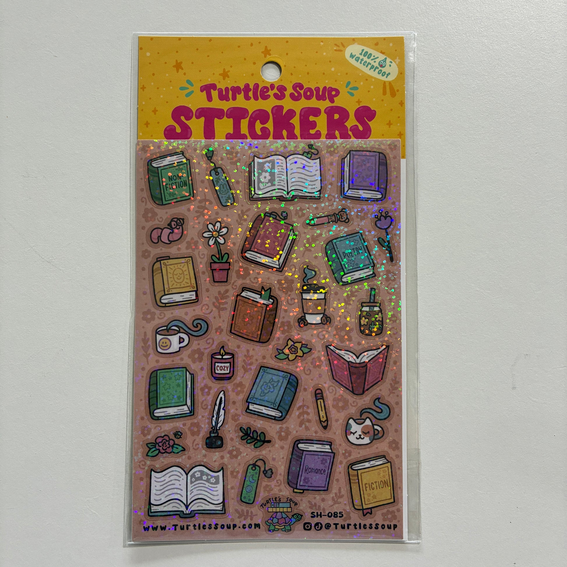A glittery sticker sheet with book illustrations on a gray background