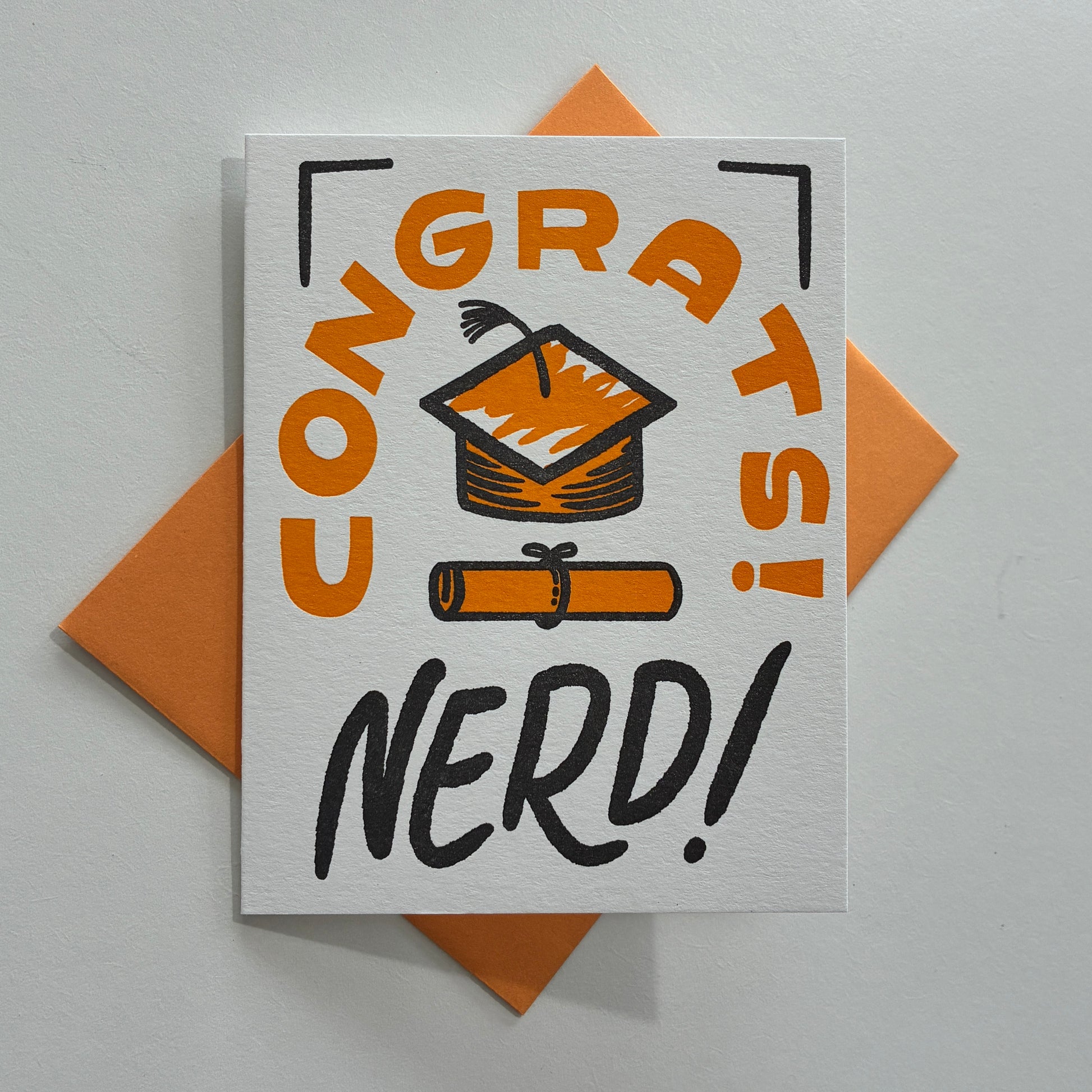 Greeting card with 'Congrats Nerd!' text and graduation cap illustration on a white background.