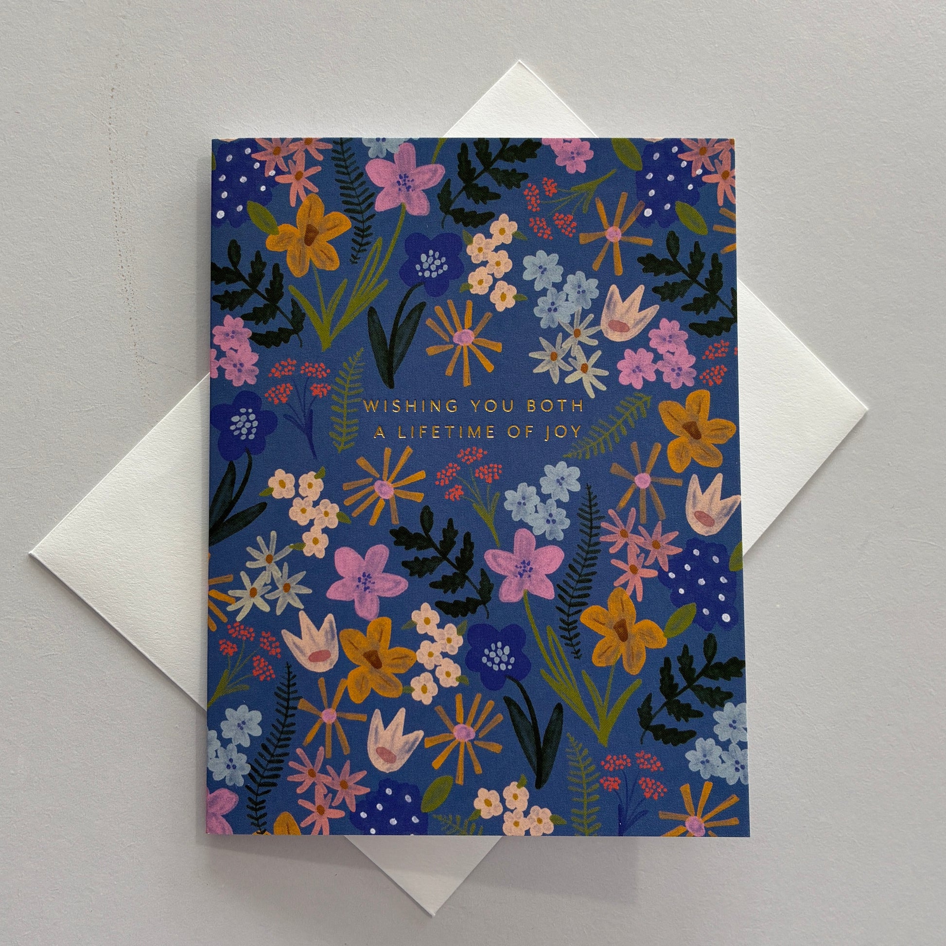 Greeting card with floral design and "wishing you both a lifetime of joy" text on a gray background