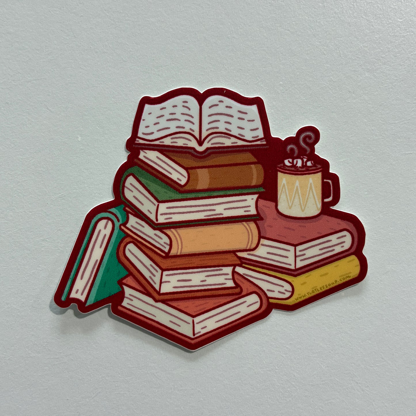 A sticker featuring a drawing of several stacked books against a gray background