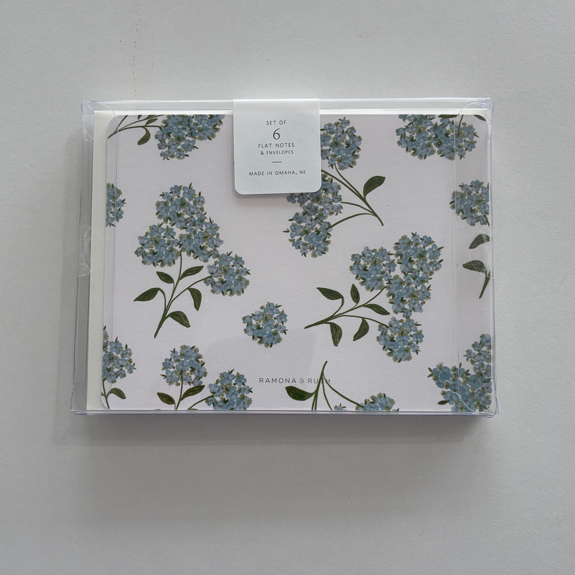Packaged set of floral notecards with a clear cover on a gray background