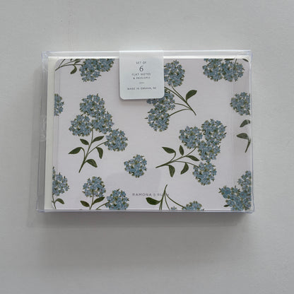 Packaged set of floral notecards with a clear cover on a gray background