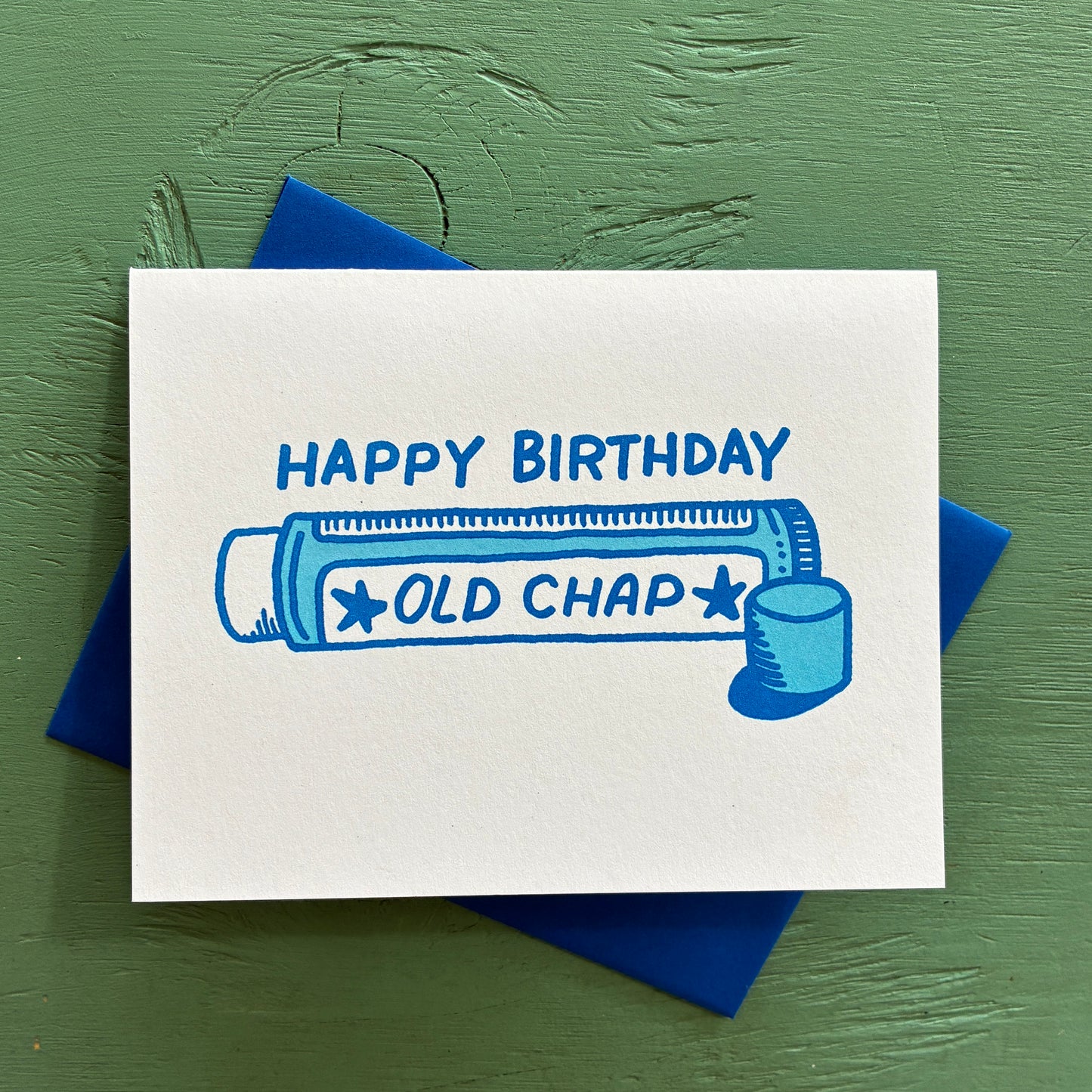 Birthday card with 'Happy Birthday Old Chap' text and illustration on a green background