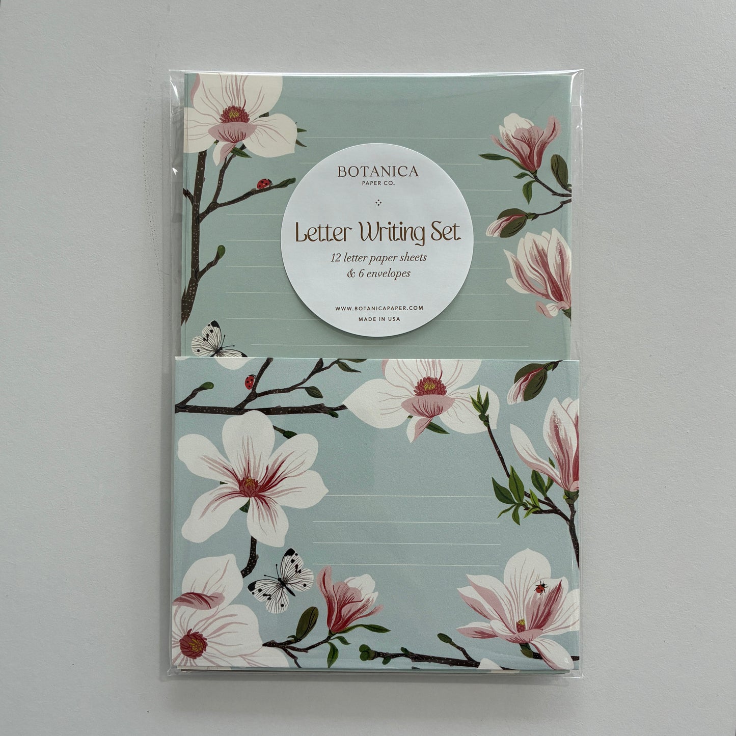 Letter writing set with floral design on a light gray background