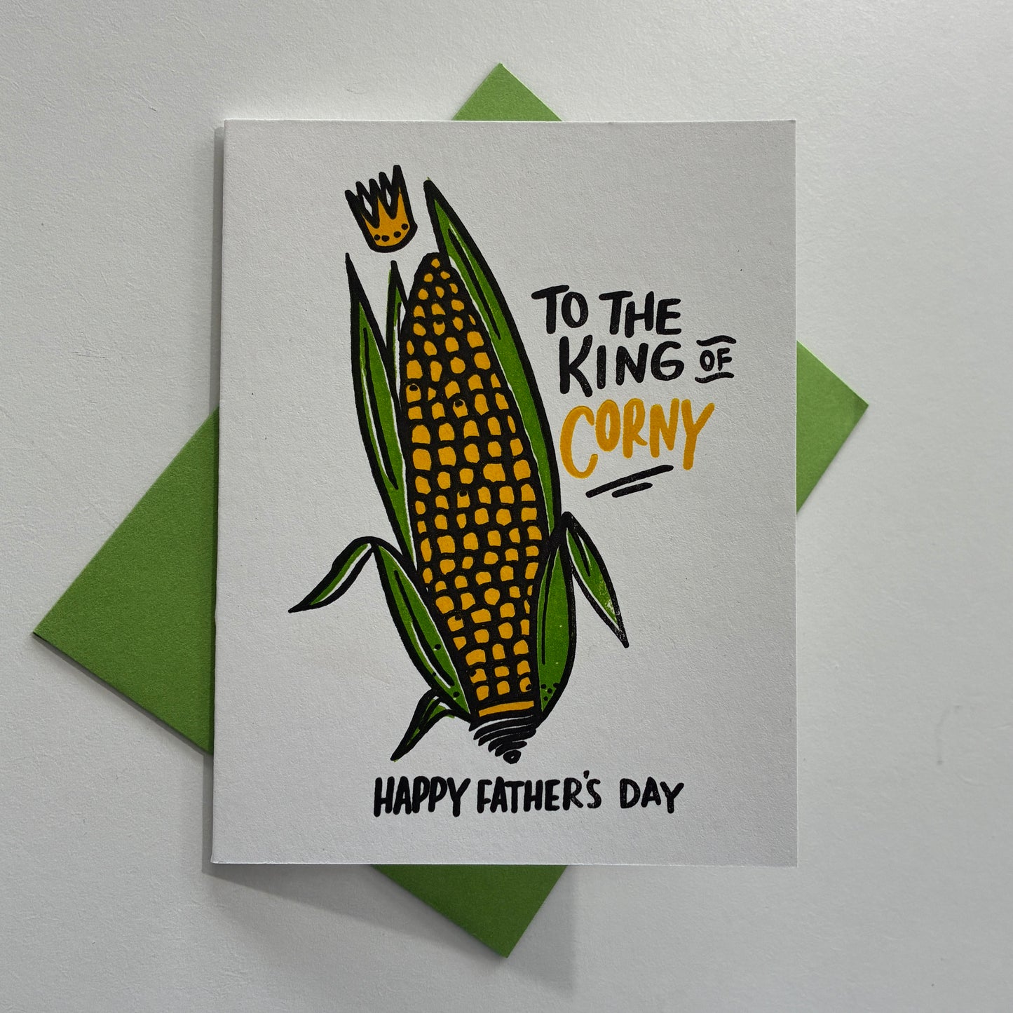 Father's Day card with corn illustration and "To the king of corny Happy Father's Day" text on a gray background