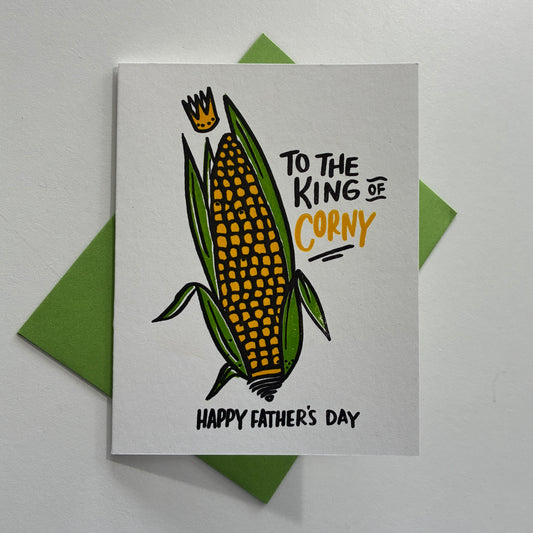 Father's Day card with corn illustration and "To the king of corny Happy Father's Day" text on a gray background