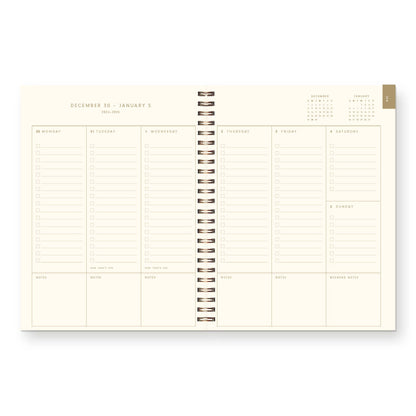 Spiral-bound planner with monthly calendar and grid layout on a white background